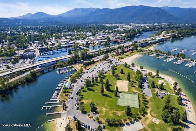 aerial view of property and surrounding area with a water and mountain view and a marina