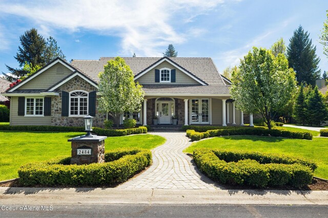 2484 E Woodstone Dr, Hayden, ID 83835 - view of front of property featuring french doors, stone siding, a front lawn, and a tiled roof