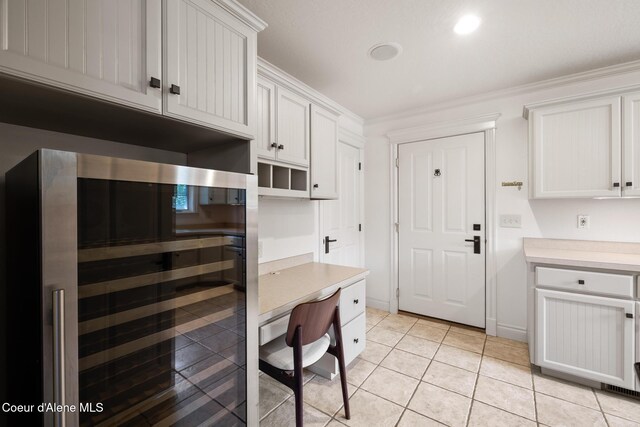 2484 E Woodstone Dr, Hayden, ID 83835 - kitchen with beverage cooler, light countertops, light tile patterned flooring, crown molding, and white cabinets