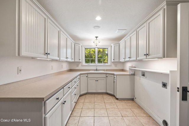 2484 E Woodstone Dr, Hayden, ID 83835 - clothes washing area with hookup for an electric dryer, light tile patterned floors, washer hookup, and cabinet space