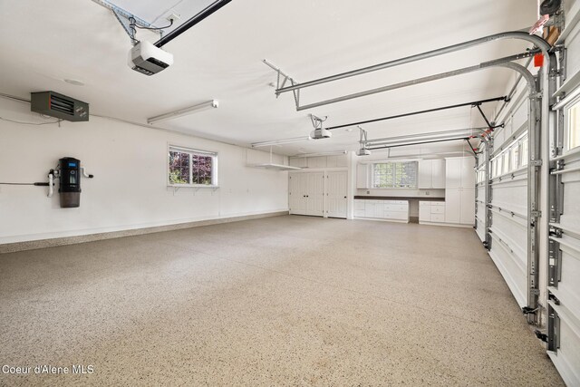 2484 E Woodstone Dr, Hayden, ID 83835 - garage featuring a garage door opener, a central vacuum unit, and baseboards
