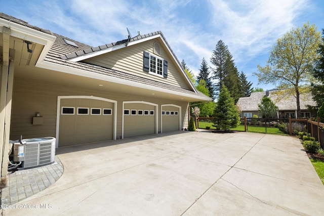 2484 E Woodstone Dr, Hayden, ID 83835 - view of side of property with cooling unit, concrete driveway, a garage, fence, and a tiled roof