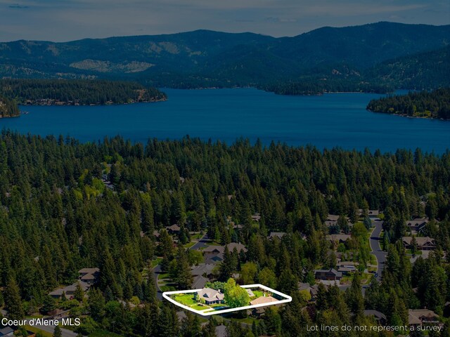 2484 E Woodstone Dr, Hayden, ID 83835 - aerial view of property and surrounding area with a forest, property parcel outlined, and a water and mountain view