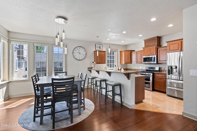 4445 W Greenchain Loop Unit 2, Coeur Dalene, ID 83814 - dining space with light wood-type flooring, baseboards, recessed lighting, and a textured ceiling