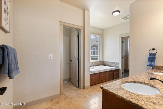 4445 W Greenchain Loop Unit 2, Coeur Dalene, ID 83814 - bathroom with a garden tub, double vanity, baseboards, and tile patterned flooring