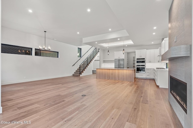 2867 W Lumber Ln, Coeur Dalene, ID 83814 - kitchen with appliances with stainless steel finishes, open floor plan, light wood finished floors, recessed lighting, and hanging light fixtures