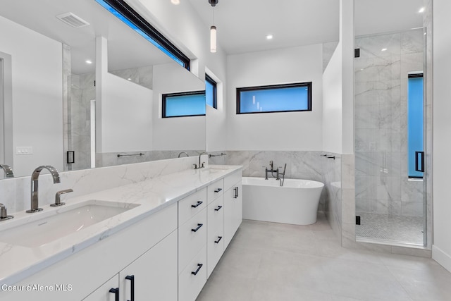 2867 W Lumber Ln, Coeur Dalene, ID 83814 - bathroom featuring a shower stall, a soaking tub, double vanity, tile walls, and tile patterned flooring