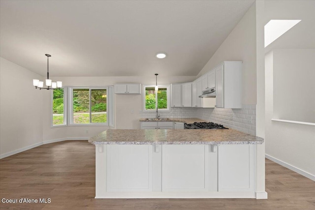 1303 N Cherrywood Dr, Coeur Dalene, ID 83814 - kitchen featuring light countertops, white cabinets, decorative backsplash, baseboards, and vaulted ceiling