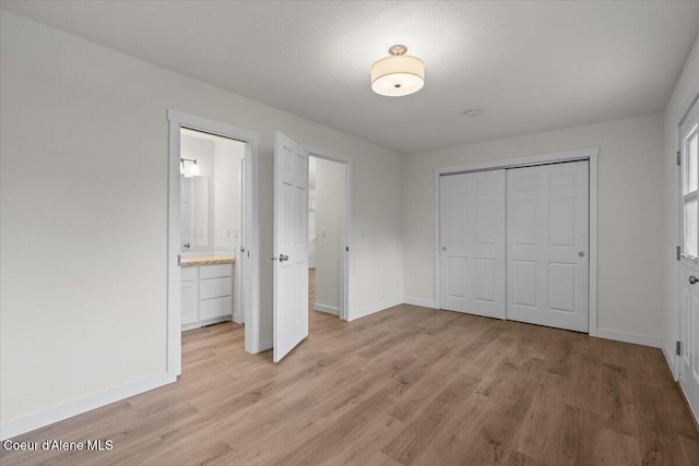1303 N Cherrywood Dr, Coeur Dalene, ID 83814 - unfurnished bedroom with light wood-style flooring, baseboards, a closet, and ensuite bathroom