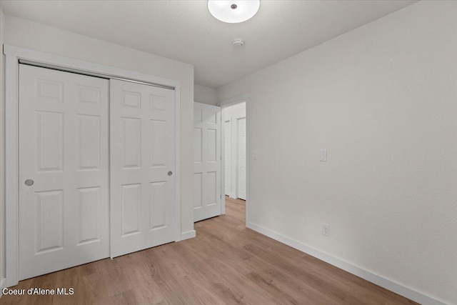 1303 N Cherrywood Dr, Coeur Dalene, ID 83814 - unfurnished bedroom featuring baseboards, light wood-style flooring, and a closet