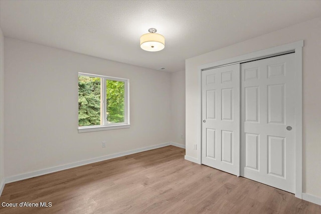 1303 N Cherrywood Dr, Coeur Dalene, ID 83814 - unfurnished bedroom featuring light wood-style floors, a closet, and baseboards