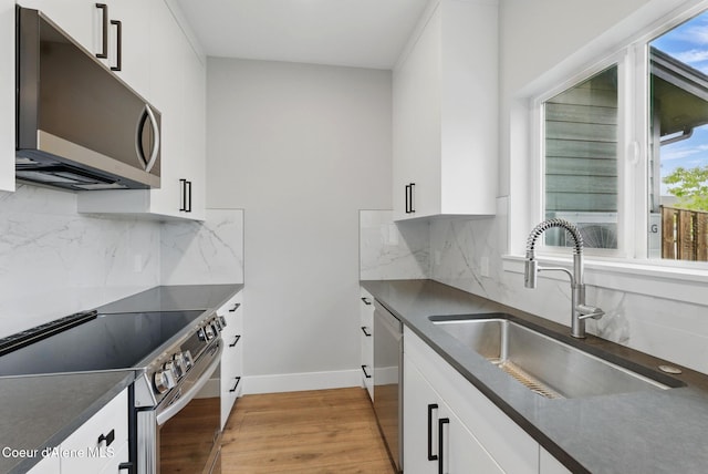 1678 Onyx Ct, Sandpoint, ID 83864 - kitchen with appliances with stainless steel finishes, a sink, dark countertops, light wood-type flooring, and white cabinets