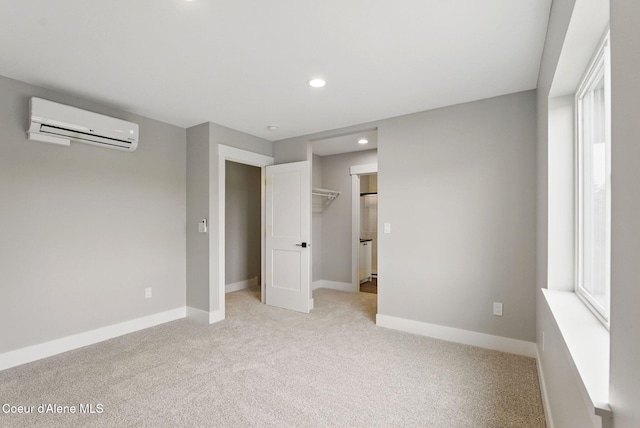 1678 Onyx Ct, Sandpoint, ID 83864 - unfurnished bedroom with a wall mounted air conditioner, light colored carpet, recessed lighting, baseboards, and a walk in closet