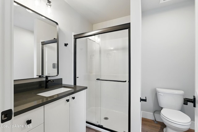 1678 Onyx Ct, Sandpoint, ID 83864 - full bathroom featuring vanity, a stall shower, toilet, wood finished floors, and baseboards
