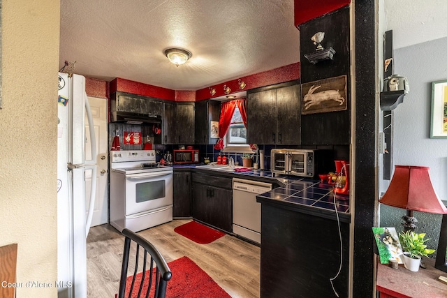 837 N 19th St, Coeur Dalene, ID 83814 - kitchen featuring white appliances, light wood finished floors, under cabinet range hood, a textured ceiling, and a sink