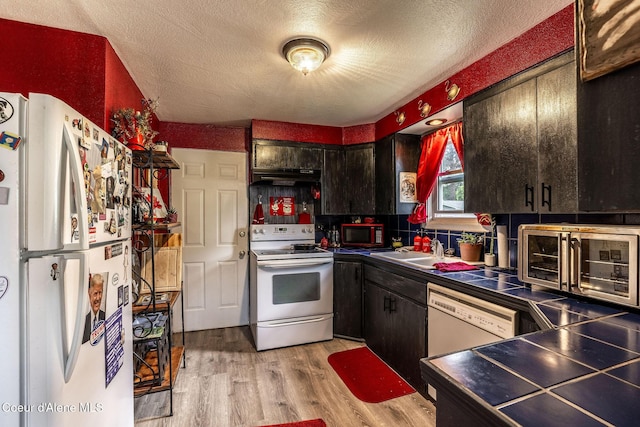 837 N 19th St, Coeur Dalene, ID 83814 - kitchen with white appliances, light wood finished floors, a sink, a textured ceiling, and under cabinet range hood