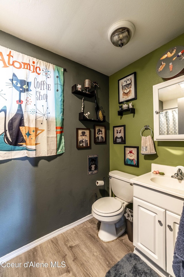 837 N 19th St, Coeur Dalene, ID 83814 - full bath with wood finished floors, toilet, vanity, and baseboards