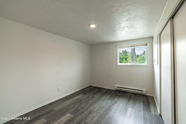 837 N 19th St, Coeur Dalene, ID 83814 - unfurnished room featuring a baseboard heating unit, dark wood finished floors, baseboards, and a textured ceiling