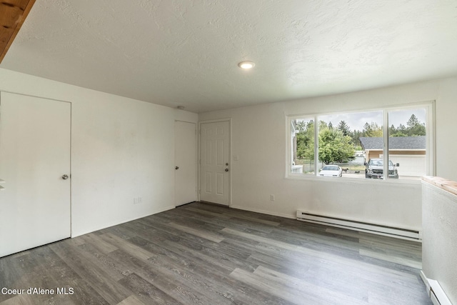 837 N 19th St, Coeur Dalene, ID 83814 - empty room featuring wood finished floors, a baseboard heating unit, a textured ceiling, a baseboard radiator, and baseboards