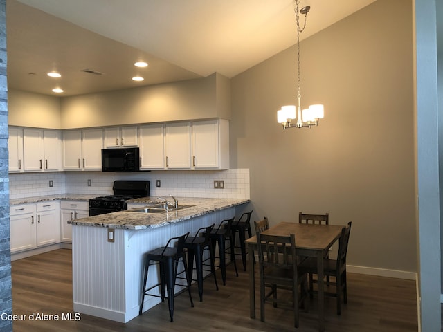 kitchen with black appliances, a chandelier, white cabinets, backsplash, and dark wood-style flooring