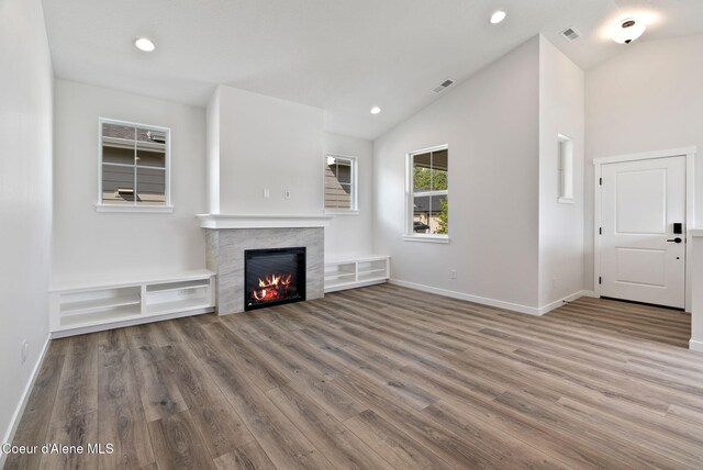 7823 N Girard Cir, Coeur Dalene, ID 83815 - unfurnished living room with a warm lit fireplace, wood finished floors, lofted ceiling, baseboards, and recessed lighting
