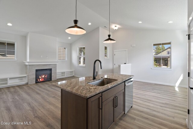 7823 N Girard Cir, Coeur Dalene, ID 83815 - kitchen featuring a sink, stainless steel dishwasher, light wood-type flooring, hanging light fixtures, and light stone countertops