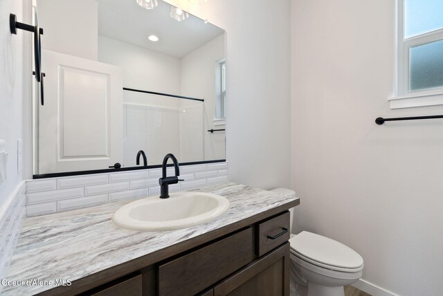 7823 N Girard Cir, Coeur Dalene, ID 83815 - full bathroom featuring tasteful backsplash, toilet, vanity, a shower, and baseboards