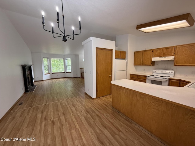 5188 E Woodland Dr, Post Falls, ID 83854 - kitchen featuring white appliances, under cabinet range hood, open floor plan, light wood finished floors, and light countertops