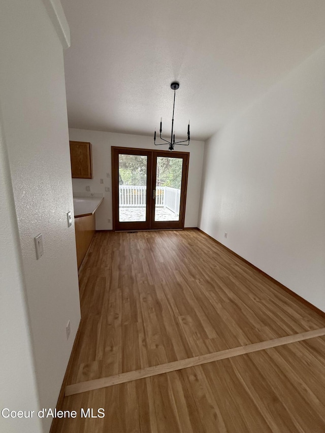 5188 E Woodland Dr, Post Falls, ID 83854 - unfurnished dining area with a chandelier and light wood-style flooring