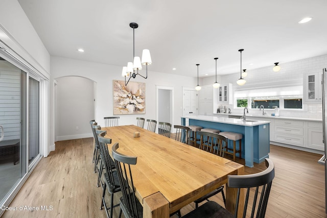 215 W Foster Ave, Coeur Dalene, ID 83814 - dining area with recessed lighting, light wood-style flooring, a chandelier, arched walkways, and baseboards