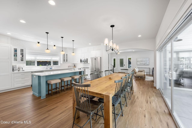 215 W Foster Ave, Coeur Dalene, ID 83814 - dining room featuring light wood-style flooring, arched walkways, and recessed lighting