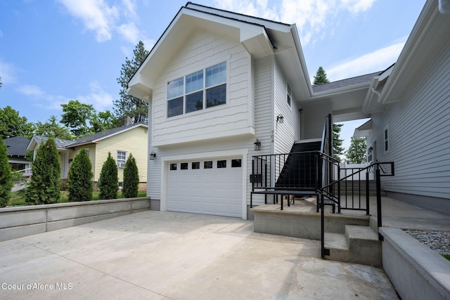 215 W Foster Ave, Coeur Dalene, ID 83814 - view of side of property with an attached garage, concrete driveway, and stairs