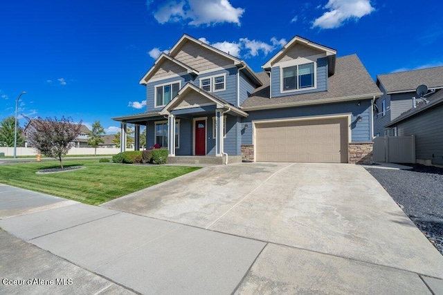 4631 E Alopex Ln, Post Falls, ID 83854 - view of front of home with concrete driveway, covered porch, stone siding, and a garage