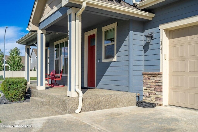 4631 E Alopex Ln, Post Falls, ID 83854 - doorway to property with covered porch, an attached garage, and stone siding