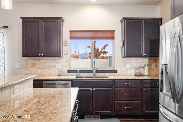 4631 E Alopex Ln, Post Falls, ID 83854 - kitchen featuring appliances with stainless steel finishes, a sink, dark brown cabinetry, and decorative backsplash