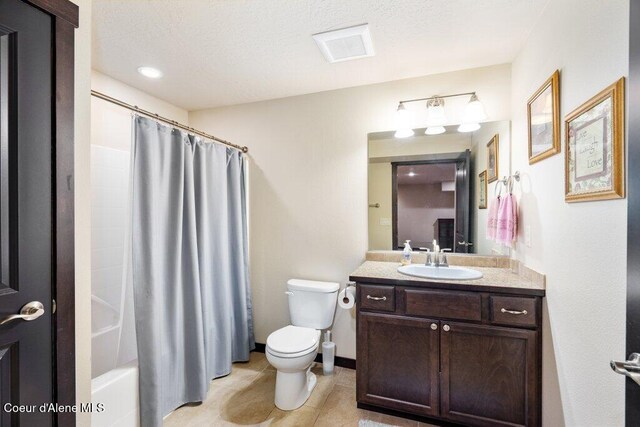 4631 E Alopex Ln, Post Falls, ID 83854 - bathroom with toilet, tile patterned floors, vanity, and shower / bath combination with curtain