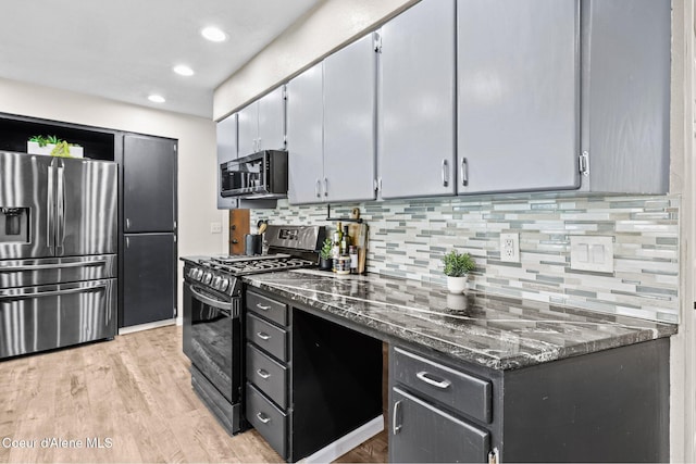 kitchen with stainless steel appliances, decorative backsplash, light wood-style flooring, dark stone countertops, and recessed lighting