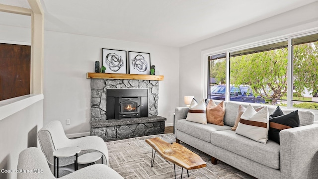 living room featuring a fireplace, baseboards, and wood finished floors
