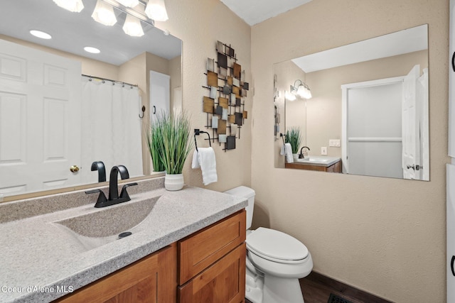 bathroom with toilet, vanity, and a shower with shower curtain