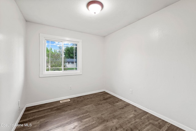 empty room with dark wood finished floors and baseboards