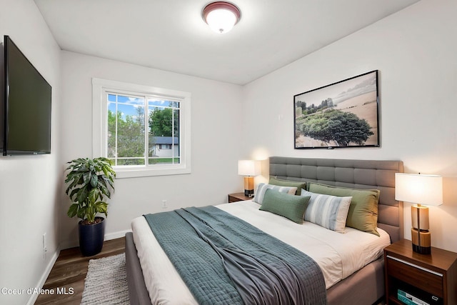bedroom with baseboards and wood finished floors