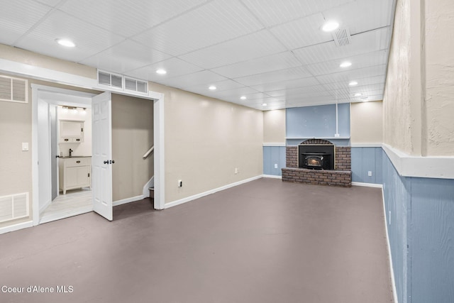 basement featuring recessed lighting, stairway, and a fireplace