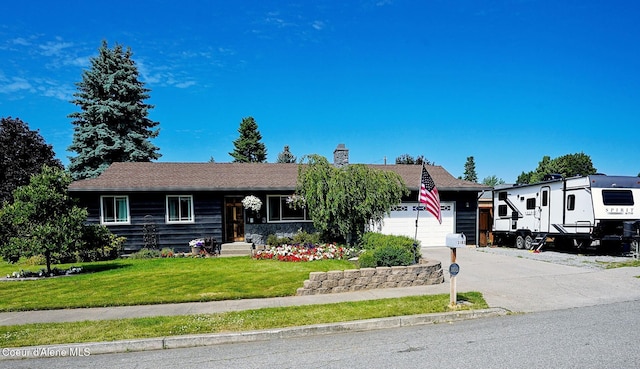 ranch-style home with concrete driveway, a chimney, a garage, and a front lawn