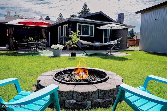 back of house featuring a fire pit, a patio area, and a chimney