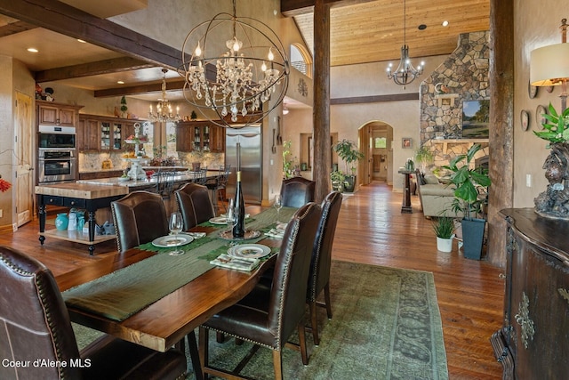 16829 S Lazurite Dr, Coeur Dalene, ID 83814 - dining area featuring a chandelier, arched walkways, beamed ceiling, and dark wood-style floors