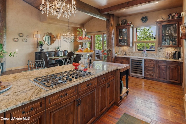 16829 S Lazurite Dr, Coeur Dalene, ID 83814 - kitchen featuring beverage cooler, stainless steel gas cooktop, a chandelier, light wood-type flooring, and backsplash