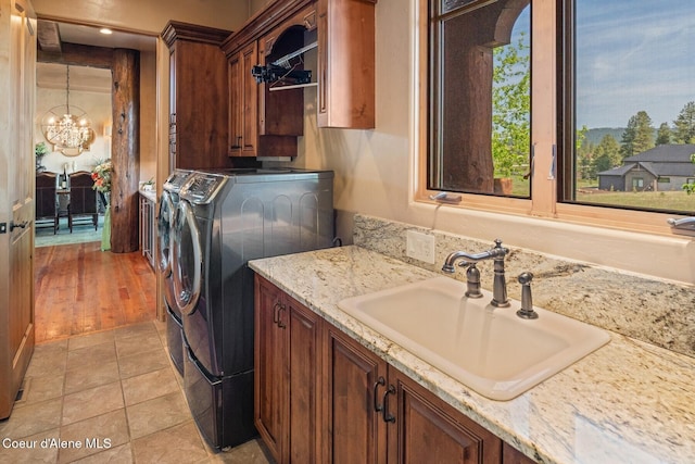 16829 S Lazurite Dr, Coeur Dalene, ID 83814 - clothes washing area with independent washer and dryer, cabinet space, a chandelier, and light tile patterned floors