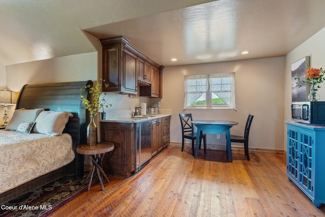16829 S Lazurite Dr, Coeur Dalene, ID 83814 - kitchen featuring stainless steel microwave, light countertops, a sink, light wood finished floors, and baseboards