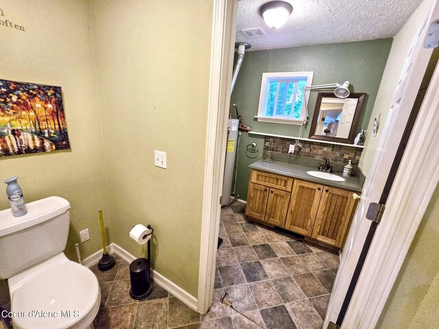 29429 N Silver Meadows Loop, Athol, ID 83801 - bathroom with toilet, vanity, backsplash, a textured ceiling, and baseboards