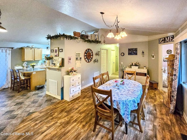 29429 N Silver Meadows Loop, Athol, ID 83801 - dining area featuring a textured ceiling, dark wood-style flooring, lofted ceiling, a chandelier, and baseboards